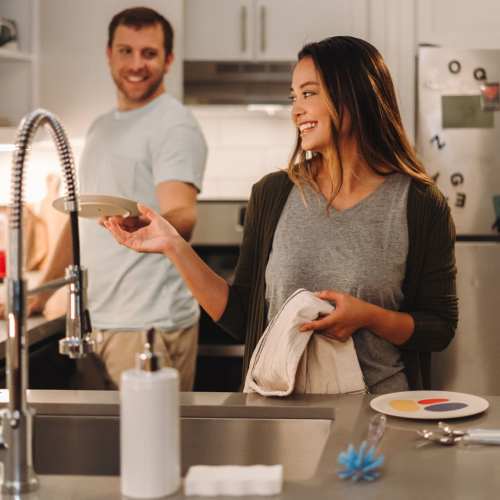 Resident couple washing dishes in their home at Sequoia 