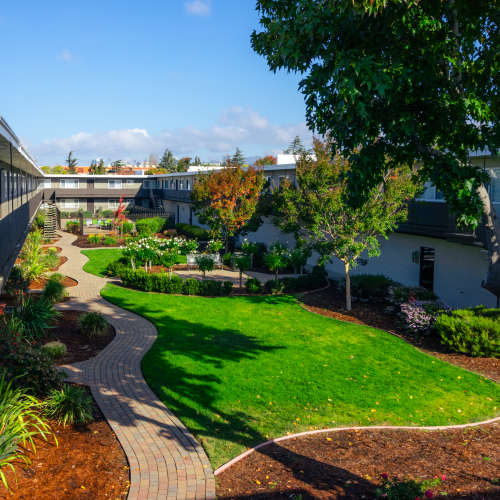 Beautifully kept lawn and walkway for residents at Garden Court Apartments in Alameda, California