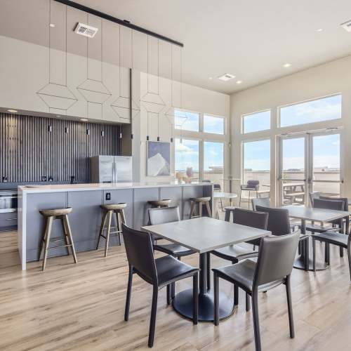 Tables and chairs by the kitchen area in the clubhouse at Elevation @ County Line Station in Englewood, Colorado