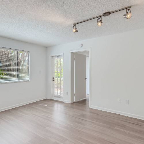 Track lighting and wood-style flooring in a home at Cascades at the Hammocks in Miami, Florida