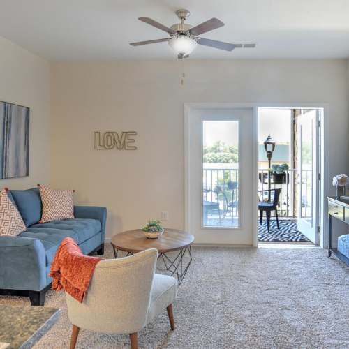 Spacious living room with a couch, and a door leading to the balcony at 10 Newbridge in Asheville, North Carolina