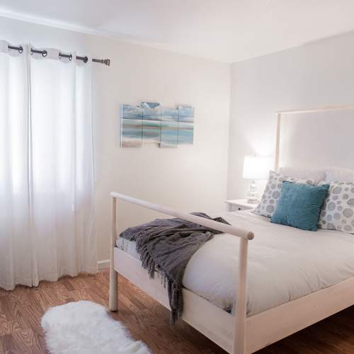 Modern bedroom with comfortable bed at Walnut Apartments in Santa Rosa, California