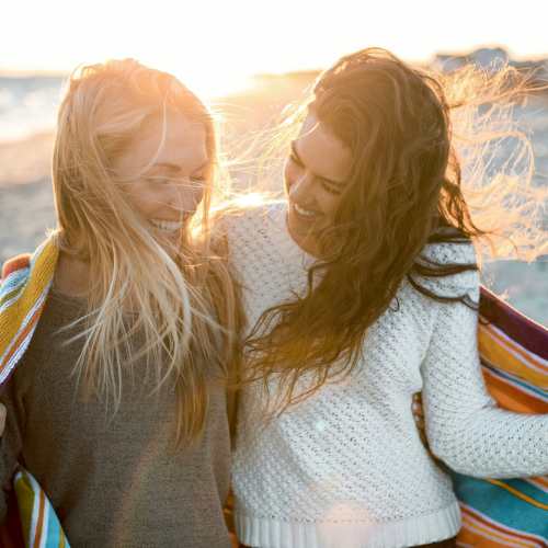 Two women having a good time at the beach near 1900 Ocean Apartment Homes in Long Beach, California