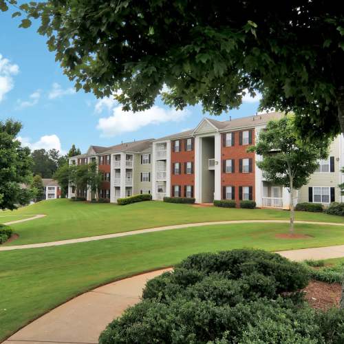 Exterior view with grassy pathway at Cherokee Summit Apartments in Acworth, Georgia