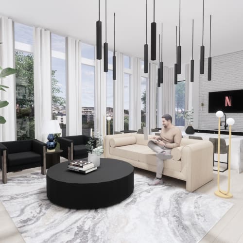 Living space with large windows, modern sofa, and wall-mounted TV at Evergreen Westside in Gainesville, Florida.