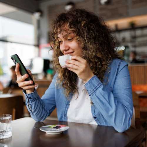 Person sitting at a table using a smartphone at Regents Park Apartments in Bensenville, Illinois