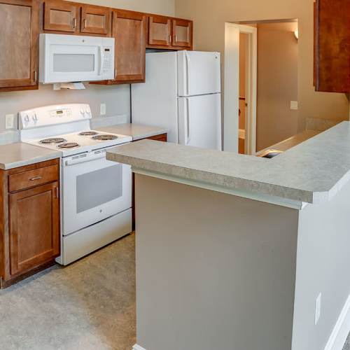 Kitchen with granite countertops and wood-style cabinets at Washington School Apartments in Washington Court House, Ohio