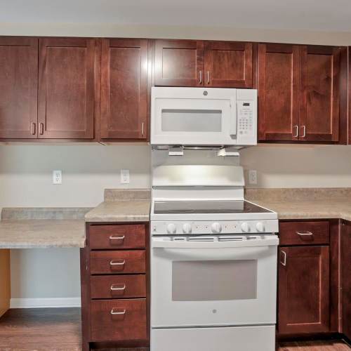 Kitchen with dark wood cabinets and stainless steel appliances at Wendler Commons in Columbus, Ohio