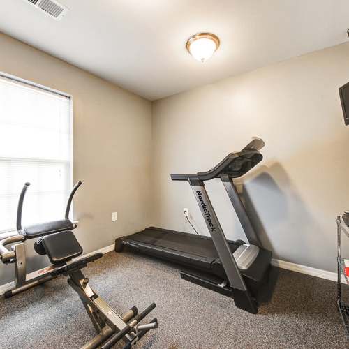 Fitness center with treadmill and weight bench at Crowfield Greene in Goose Creek, South Carolina