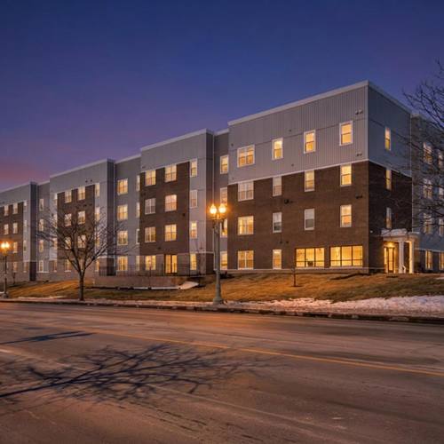 Building exterior with illuminated windows at Newton Family Apartments in Canton, Ohio
