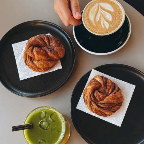 Modern coffee cup with latte art and pastries at Chapel Creek in Mandeville, Louisiana