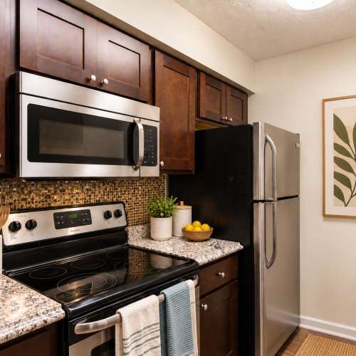 Modern kitchen with espresso cabinets and stainless steel appliances at Chase Lea Apartment Homes in Owings Mills, Maryland 