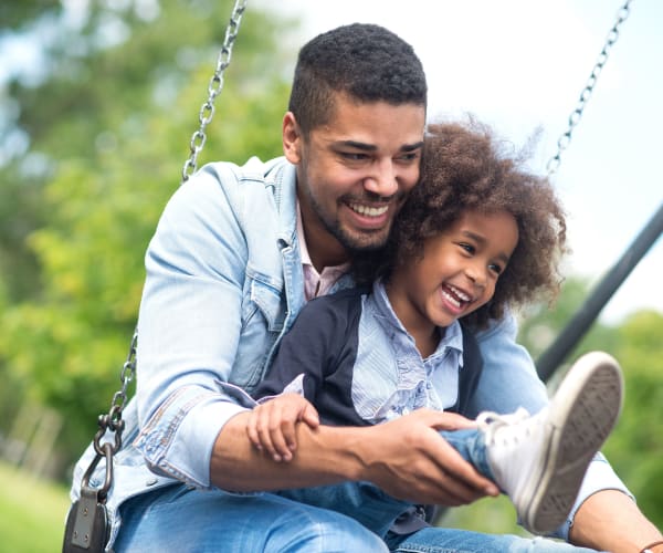 a father and daughter playing on the swings at Gold Coast in Patuxent River, Maryland