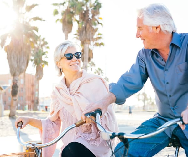 Two residents riding on bicycles outdoors at Pacifica Senior Living Santa Rosa in Santa Rosa, California