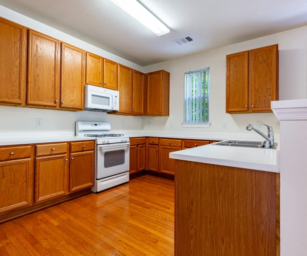 A kitchen with a microwave and gas range at Neville Heights in Quantico, Virginia