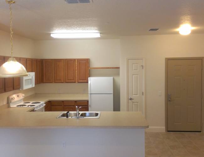 Kitchen with white appliances  and breakfast countertop at Magnolia Place in New Port Richey, Florida