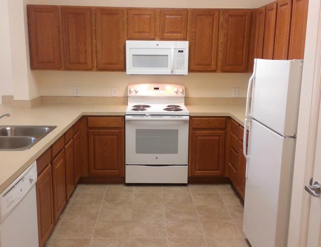 Kitchen with white appliances at Magnolia Place in New Port Richey, Florida