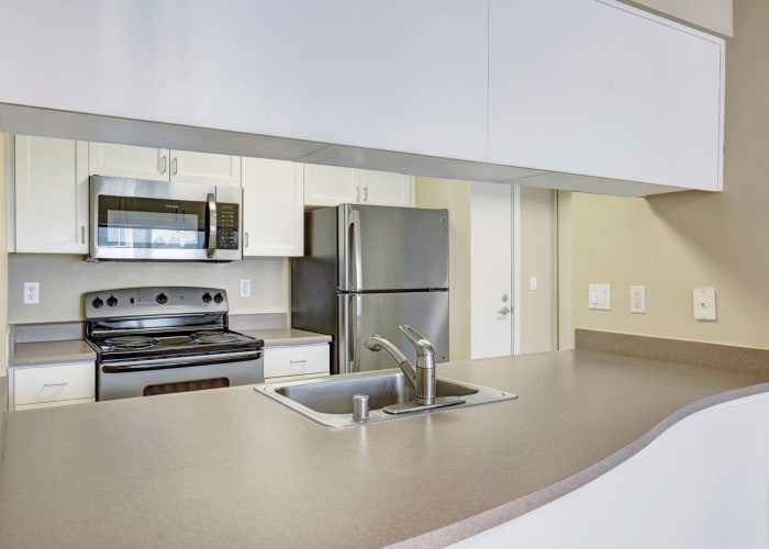 Modern kitchen with stainless-steel appliances in a model home at Vantage Park Apartments in Seattle, Washington