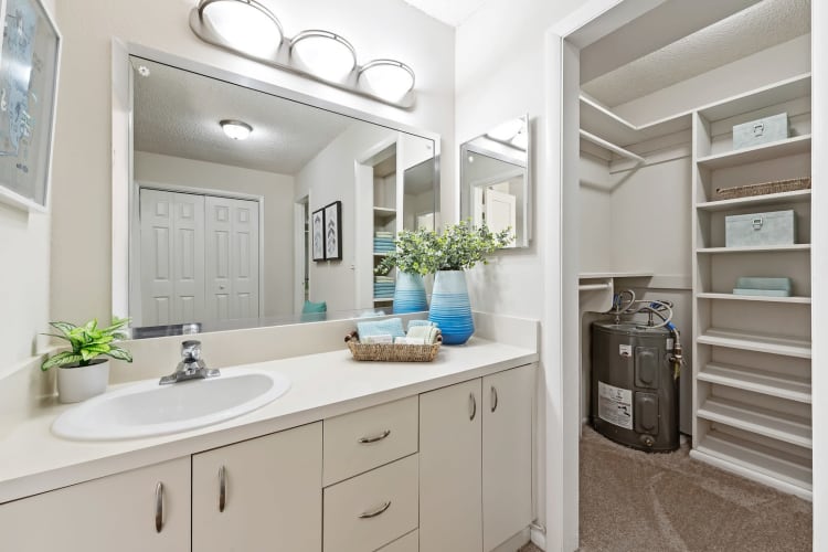 Model bathroom with plenty of storage and white cabinetry at Executive Apartments in Miami Lakes, Florida