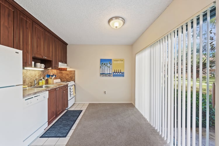 Kitchen area and sliding glass door for patio access at Executive Apartments in Miami Lakes, Florida