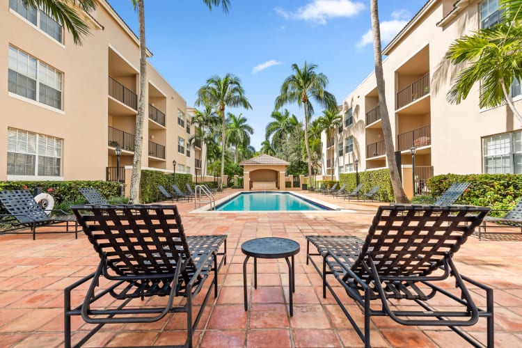 Swimming pool surrounded by lounge chairs at St. Tropez Apartments in Miami Lakes, Florida