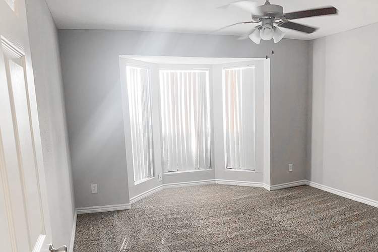 Bright bedroom with large windows and ceiling fan at Oaks of Wimbledon in Spring, Texas, 