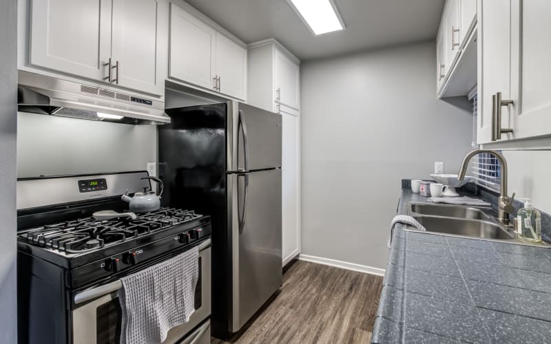 A renovated kitchen with white cabinets at Kendallwood Apartments in Whittier, California