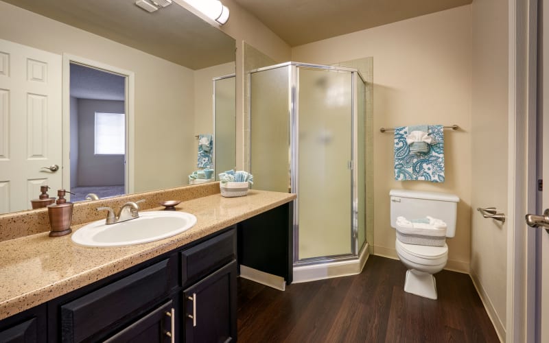 Renovated bathroom with brown cabinets at Bluesky Landing Apartments in Lakewood, Colorado