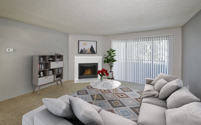 Spacious and bright living room with a fireplace at Alton Green Apartments in Denver, Colorado