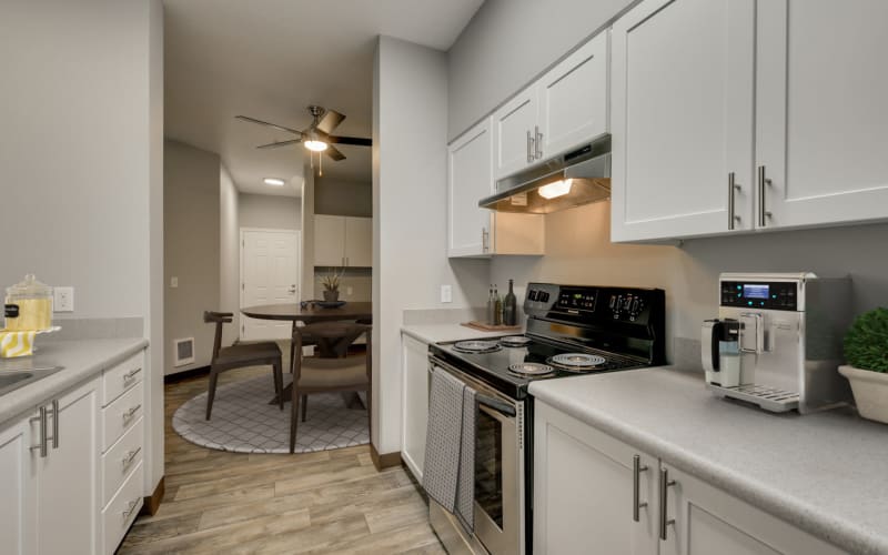 A bright and clean kitchen with white cabinets at The Landings at Morrison Apartments in Gresham, Oregon