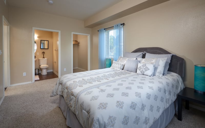 Spacious master bedroom with attached bathroom at Crossroads at City Center Apartments in Aurora, Colorado