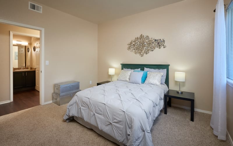 Spacious master bedroom with plush carpeting at Crossroads at City Center Apartments in Aurora, Colorado