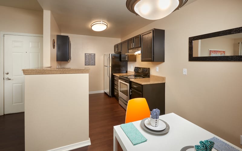 Renovated kitchen with espresso cabinets at Crossroads at City Center Apartments in Aurora, Colorado