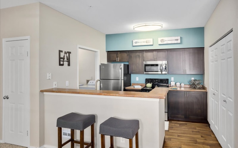 Renovated kitchen with brown cabinetry at Wildreed Apartments in Everett, Washington