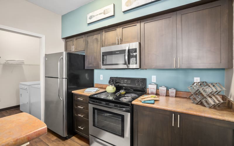 Renovated kitchen with a breakfast bar, stainless steel appliances and brown cabinets at Wildreed Apartments in Everett, Washington