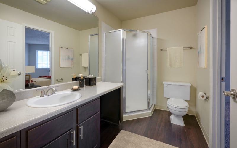 Renovated bathroom with brown cabinets at Bluesky Landing Apartments in Lakewood, Colorado