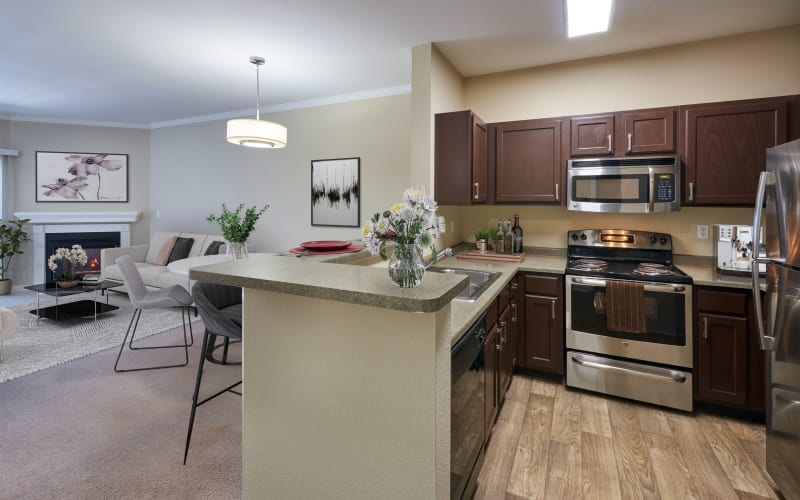 Newly renovated brown cabinet kitchen with bright lighting at Skyecrest Apartments in Lakewood, Colorado