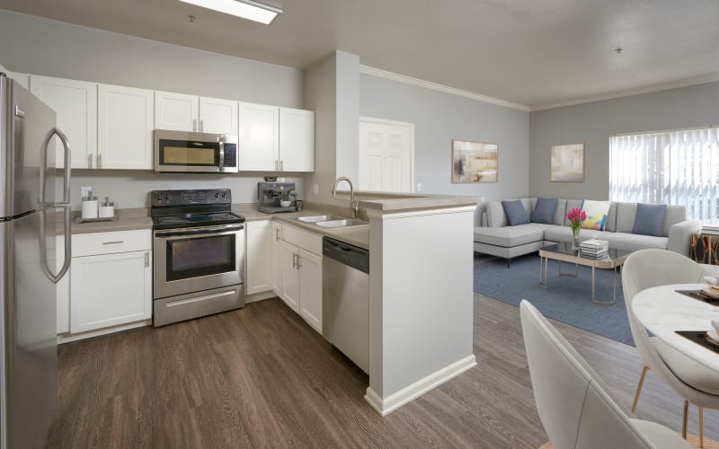 Spacious and bright dining room and kitchen with white cabinets at Westridge Apartments in Aurora, Colorado
