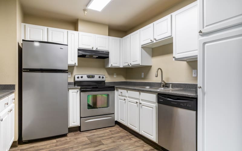 Renovated kitchen with white cabinets at Pebble Cove Apartments in Renton, Washington