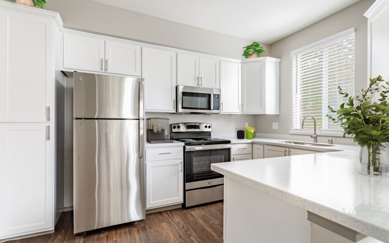 A spacious kitchen with white cabinets at Brookside Village in Auburn, Washington