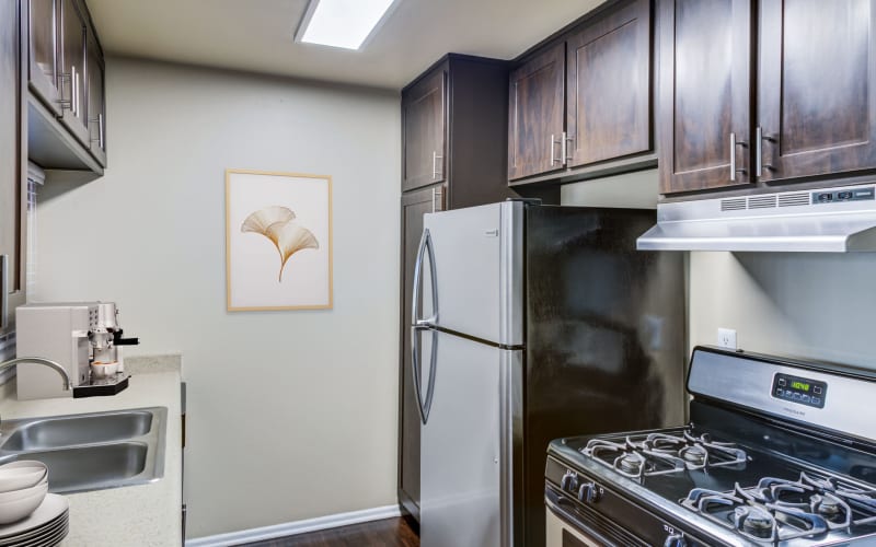 Spacious dining room and kitchen with hardwood-style floors at Kendallwood Apartments in Whittier, California