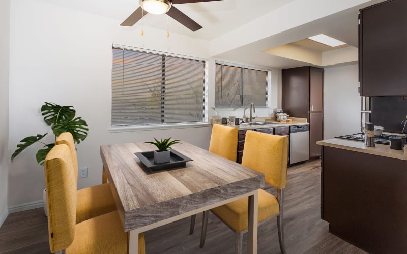 Spacious Dining Room and Kitchen with Renovated Brown Cabinetry at Shadowbrook Apartments in West Valley City, Utah