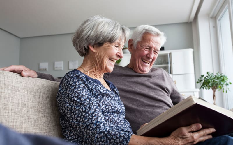 Couple looking at old photographs at Grand Villa Senior Living in Clearwater, Florida