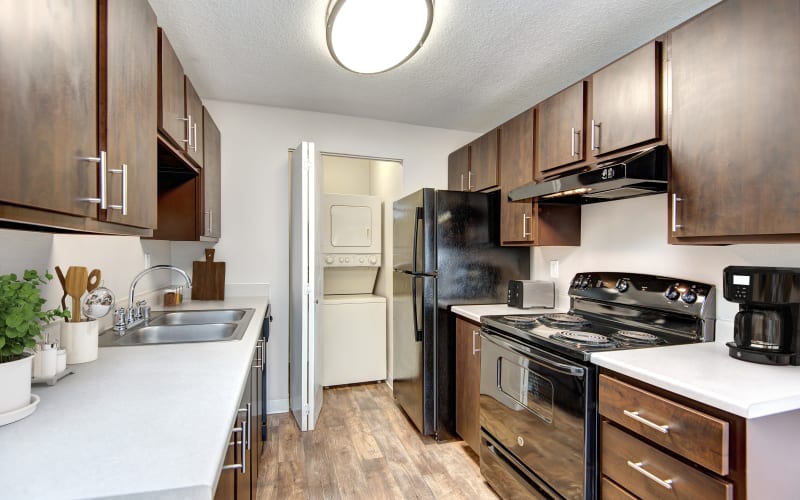 An updated kitchen with brown wood cabinets at Wellington Apartment Homes in Silverdale, Washington