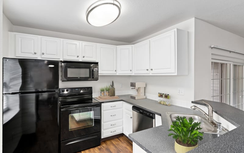 Black appliances and white cabinets in a renovated kitchen at Autumn Chase Apartments in Vancouver, Washington