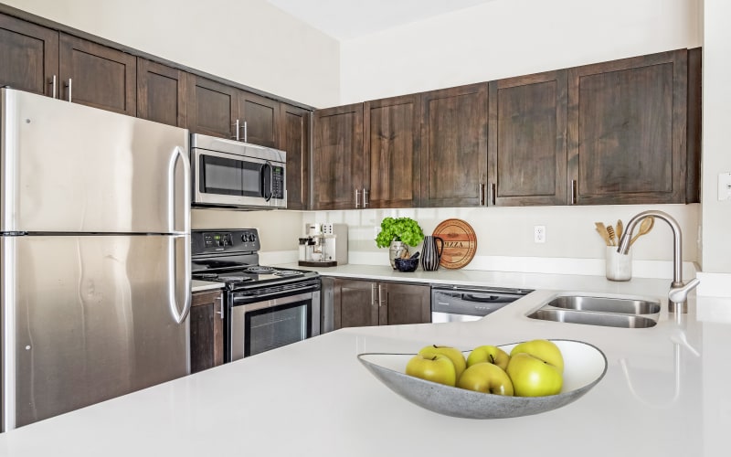 Renovated brown kitchen with quartz counters at HighGrove Apartments in Everett, Washington