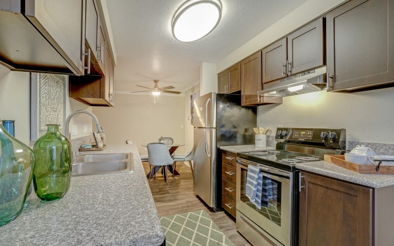 Espresso cabinets in the kitchen overlooking the dining room at Walnut Grove Landing Apartments in Vancouver, Washington