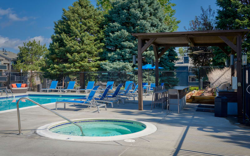 Covered barbecue area near the swimming pool at dusk at Alton Green Apartments in Denver, Colorado