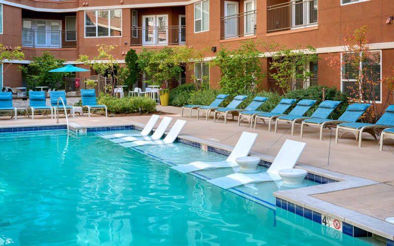 Large sparkling pool and lounge area at Helios in Englewood, Colorado