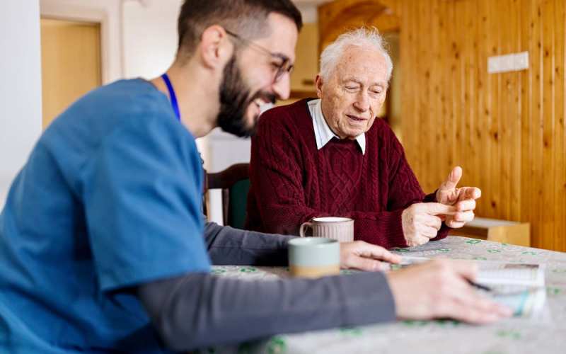 Resident having coffee with a caregiver at Tuscan Gardens of Venetia Bay in Venice, Florida